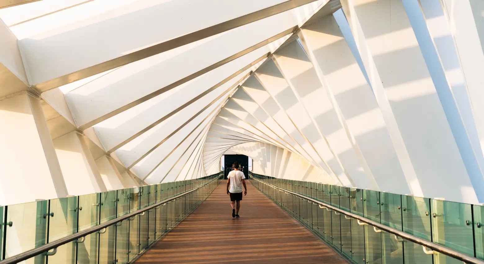 Persona caminando sobre un puente entre arquitectura moderna 