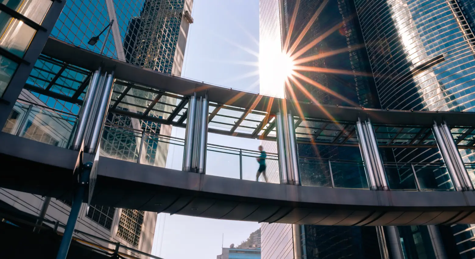 Persona caminando sobre un puente entre arquitectura moderna 