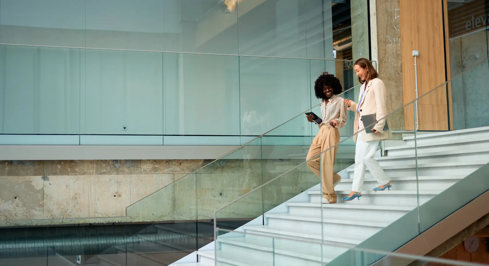 Dos mujeres caminando y hablando en un edificio moderno 