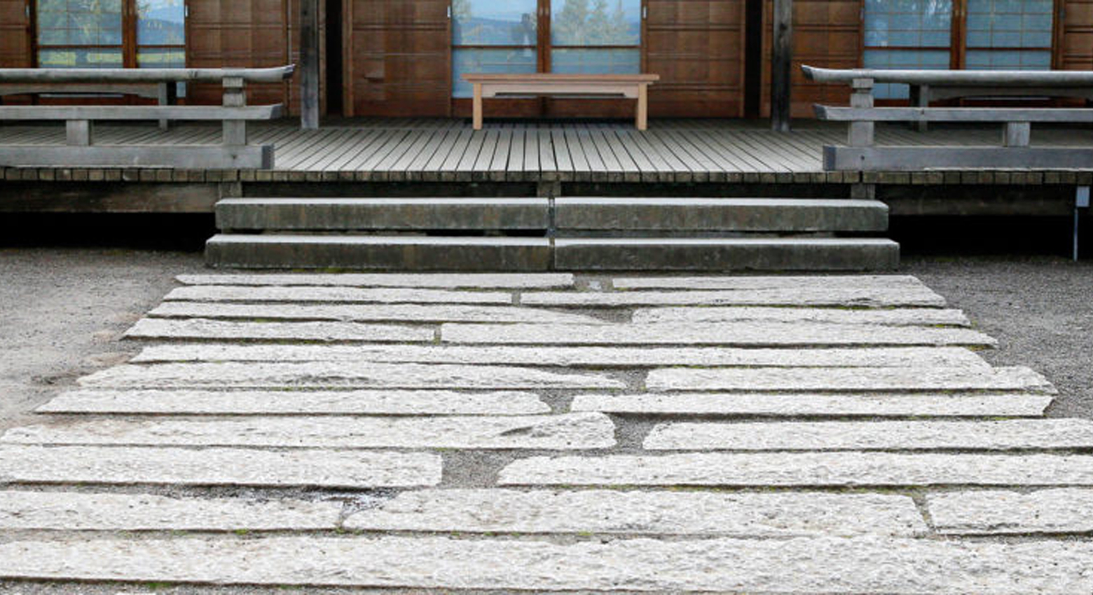 Camino de piedra que conduce al edificio y al banco 