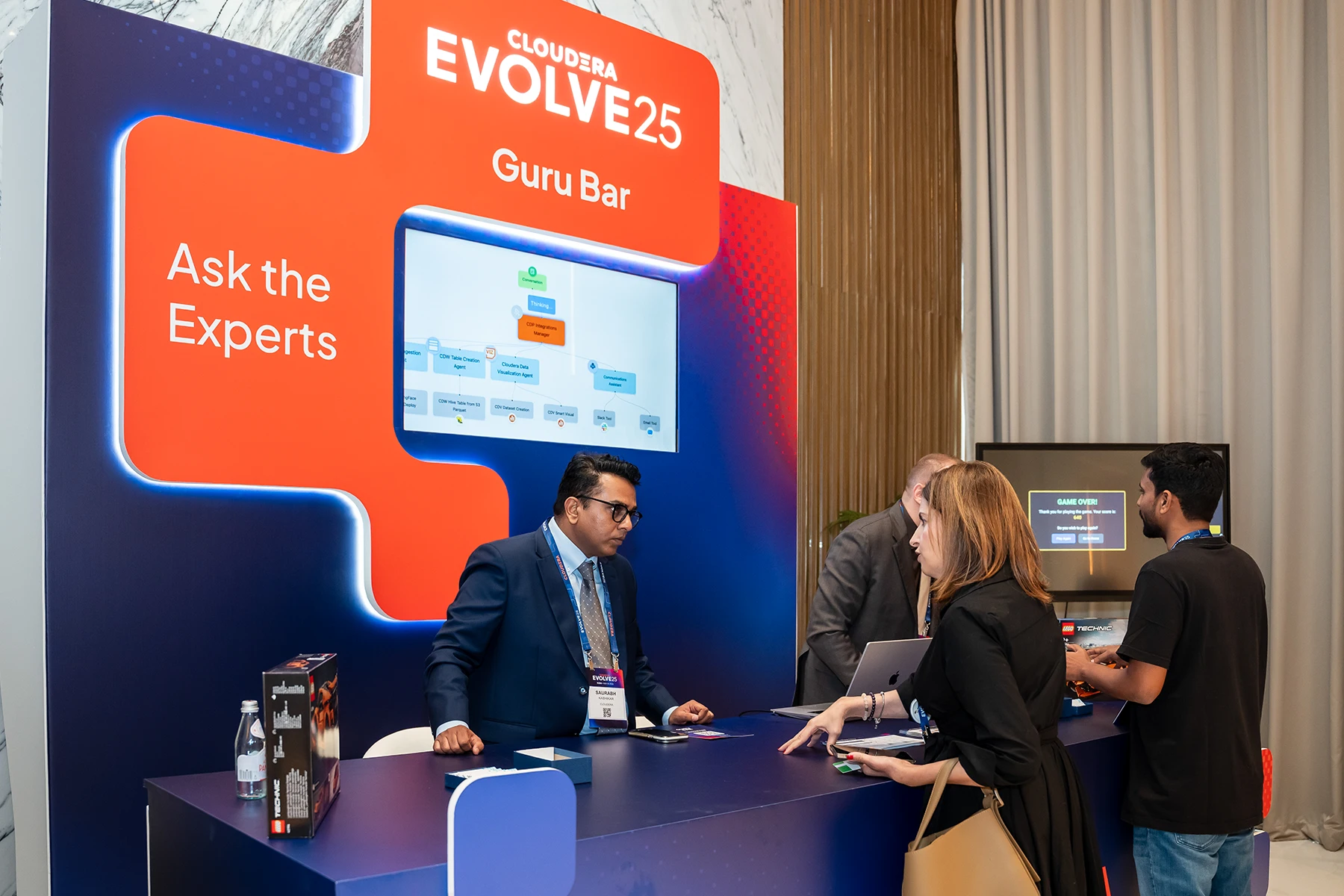 A pavilion booth & Cloudera Guru Bar with people in discussions. 